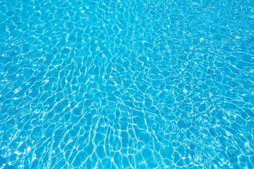 Wonderful blue water surface with sun reflection in swimming pool