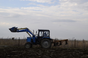 Fototapeta premium Tractor plowing the garden. Plowing the soil in the garden