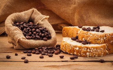 Close up  of Coffee beans and bread setup on shabby wooden backg