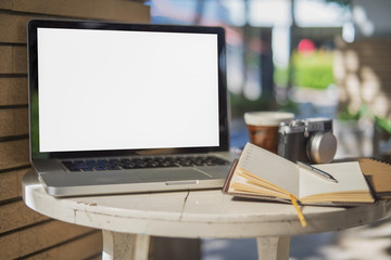 White table with a cup of coffee ,camera and laptop