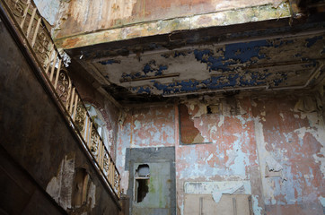 An old abandoned derelict hallway and stairs with peeling paint , in an abandoned building. Exploring urban decay.