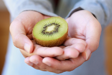 holding fresh kiwi fruit