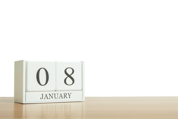 Closeup surface white wooden calendar with black 8 january word on blurred brown wood desk isolated on white background with copy space , selective focus at the calendar
