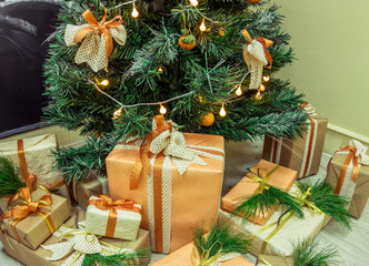 Fototapeta na wymiar Christmas gifts in kraft bumane under the Christmas tree