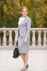 Fototapeta premium Red haired business women in grey suit
