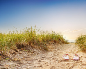 Kick your shoes off - flip flops on a sandy boardwalk over the dunes