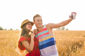 Young happy couple taking a selfie in the field