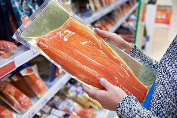 Woman buys in supermarket salted salmon