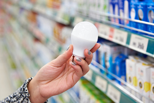 Energy saving LED lamp in hands of buyer at store