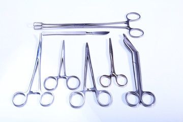 surgical instruments and tools including scalpels, forceps tweezers arranged on a table for surgery