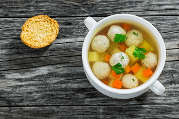  chicken soup with meatballs, carrot and potato sprinkled with p