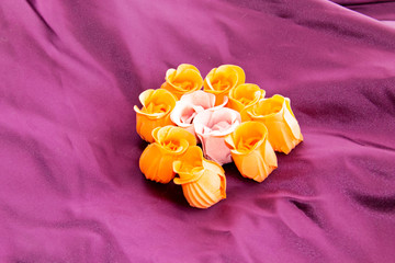 Roses shaped soap on purple silk background
