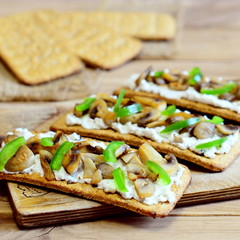 Diet appetizer with roasted mushrooms and fresh green bell pepper on a wooden board. Easy and healthy vegetarian snack. Home made recipe. Closeup