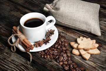 Coffee composition with black coffee, cinnamon and cookies on the old wooden table  