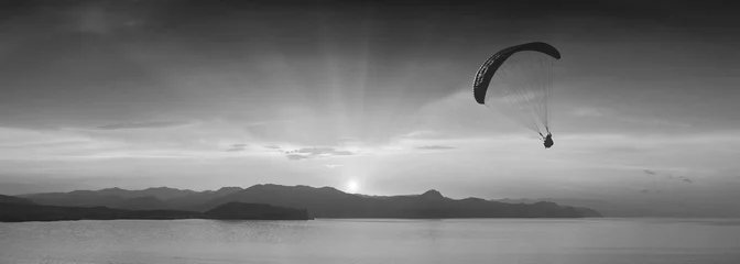 Photo sur Plexiglas Sports aériens Au-dessus de la mer contre le coucher du soleil. Monochrome