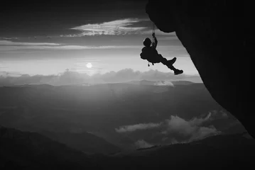Rolgordijnen Climber against sunset background. Black and white © Bashkatov