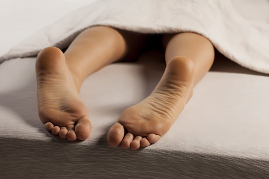 woman's feet and legs covered with a towel