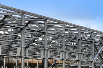 Metal frame of an industrial building, warehouse in the construction process in perspective.