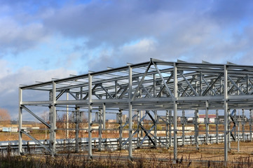 Metal frame of an industrial building, warehouse in the construction process in perspective.