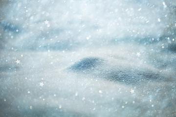 Beautiful blurred soft blue colored snow with abstract star snowfall Christmas decorations. Selective focus used.