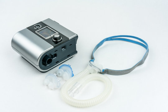 CPAP machine with hose and mask for nose. Treatment for people with sleep apnea, respiratory, or breathing disorder.
