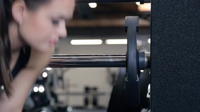 athlete removes iron wheels with barbells for bench press in gym