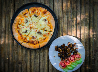 Delicious pizza with mushrooms - on wooden desk