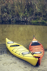 Camping with kayaks on the river bank.
