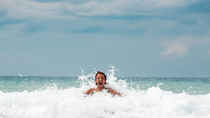 Splashing wave hits a girl. Wave like a crown. Girl screaming wi © Panksvatouny