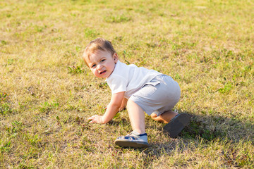 Happiness Baby boy sitting on the grass in field
