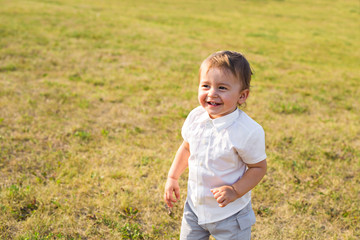 Portrait of smiling happy baby boy on natural background in summer