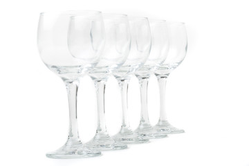 Wine glasses arranged on a table, isolated over white