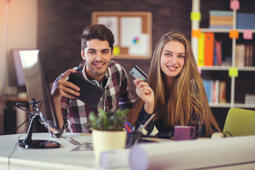 Couple of web designers working together at modern office, using