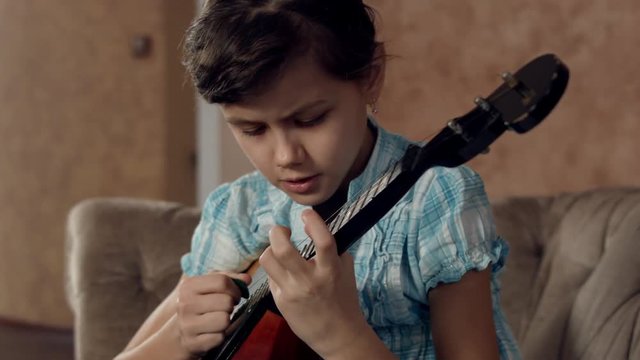 Girl learning to play mandolin ( domra)