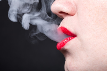 Profile view of a woman with vapor escaping from her lips