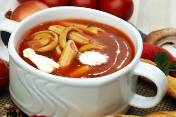 Tomato, red pepper soup, sauce with olive oil, rosemary and smoked paprika on a wooden background.