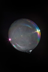 Floating soap bubble filled with smoke isolated on a black background