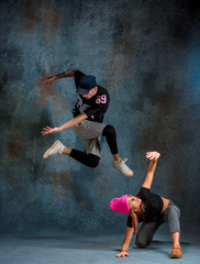 Fototapeta na wymiar The two young girl and boy dancing hip hop in the studio