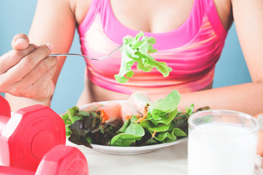 Female fitness eating fresh salad and milk, Healthy lifestyle concept