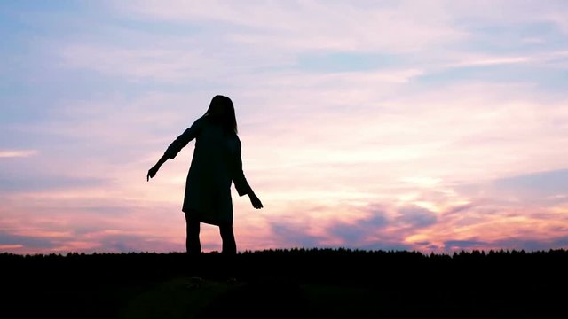 Silhouette girl masterly performing a dance on sky background.