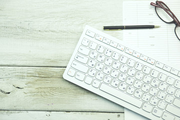 White laptop with notepad and pen on working table