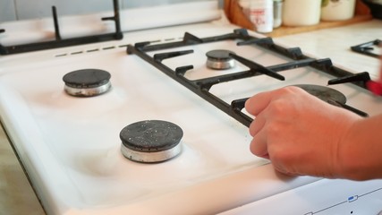woman washes a gas stove cleaning in the kitchen