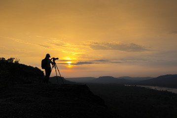 Photographer siluate at sunrise, Pha Taem National Park, Ubon Ratchathani, Thailand