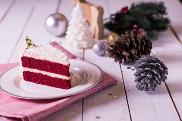 Christmas cake on plate on red fabric on wood background and dec