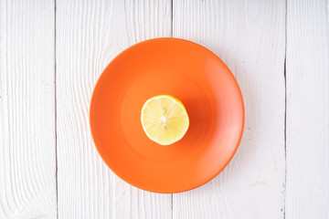 Half of lemon on orange plate