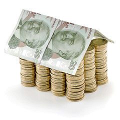 Turkish lira banknote as a roof at the top of stack of coins as concept related to real estate...