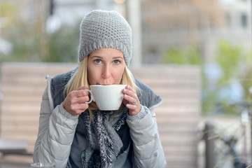 Junge Frau genießt einen heißen Kaffee im Winter