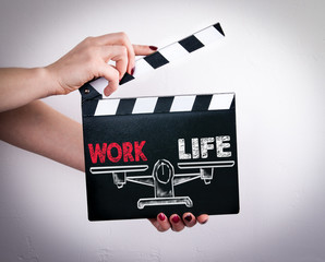 Work Life Balance. Female hands holding movie clapper. 