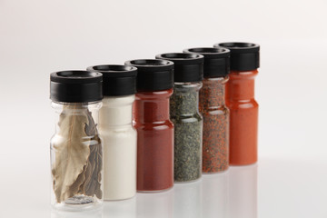 Various spices in small glass bottles, close up