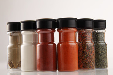 Various spices in small glass bottles, close up